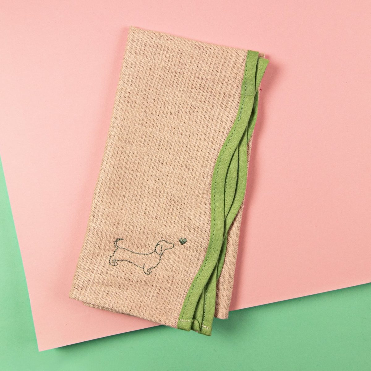 Elegant napkins with a wave shape and dachshund embroidery in different colours