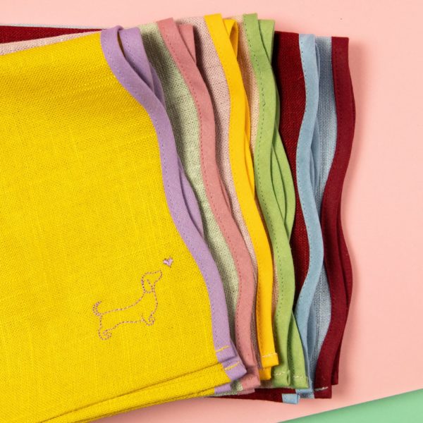 Elegant napkins with a wave shape and dachshund embroidery in different colours